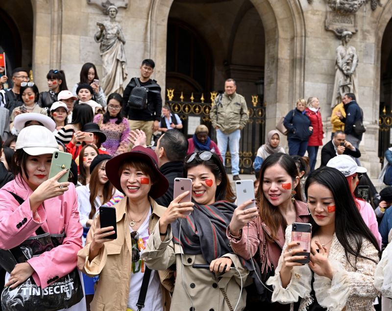 Chinese tourists take selfie in front of Opera Garnier in Paris, France