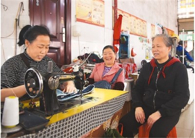 湖南省通道侗族自治县城东大市场，裁缝在给市民缝补衣服