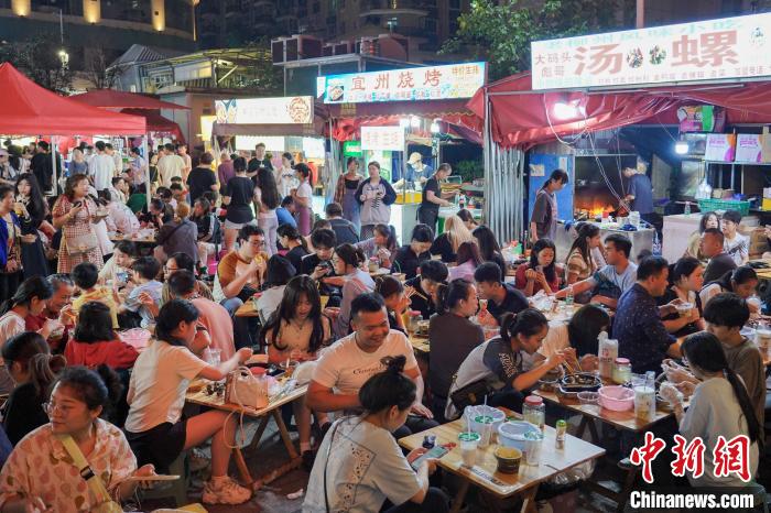 游客在柳州市风情港便民夜市品尝美食