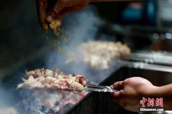 山东淄博一家烧烤店的厨师正在烤制肉串