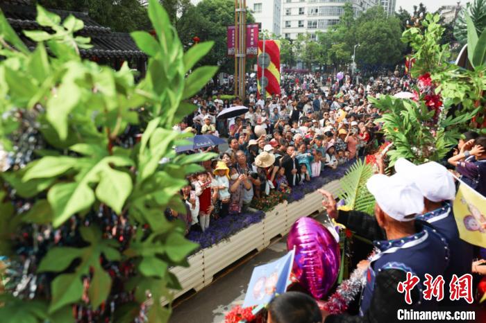 图为双胞胎们在花车上与观众频频互动