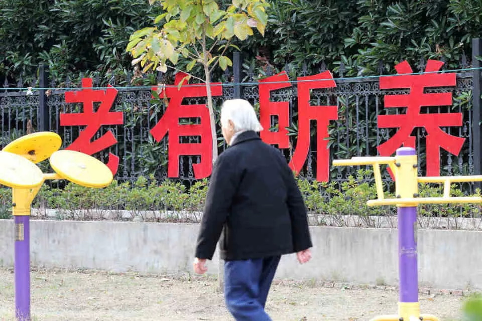 江苏省南通市一老年公寓老人在“老有所养”大字前走过