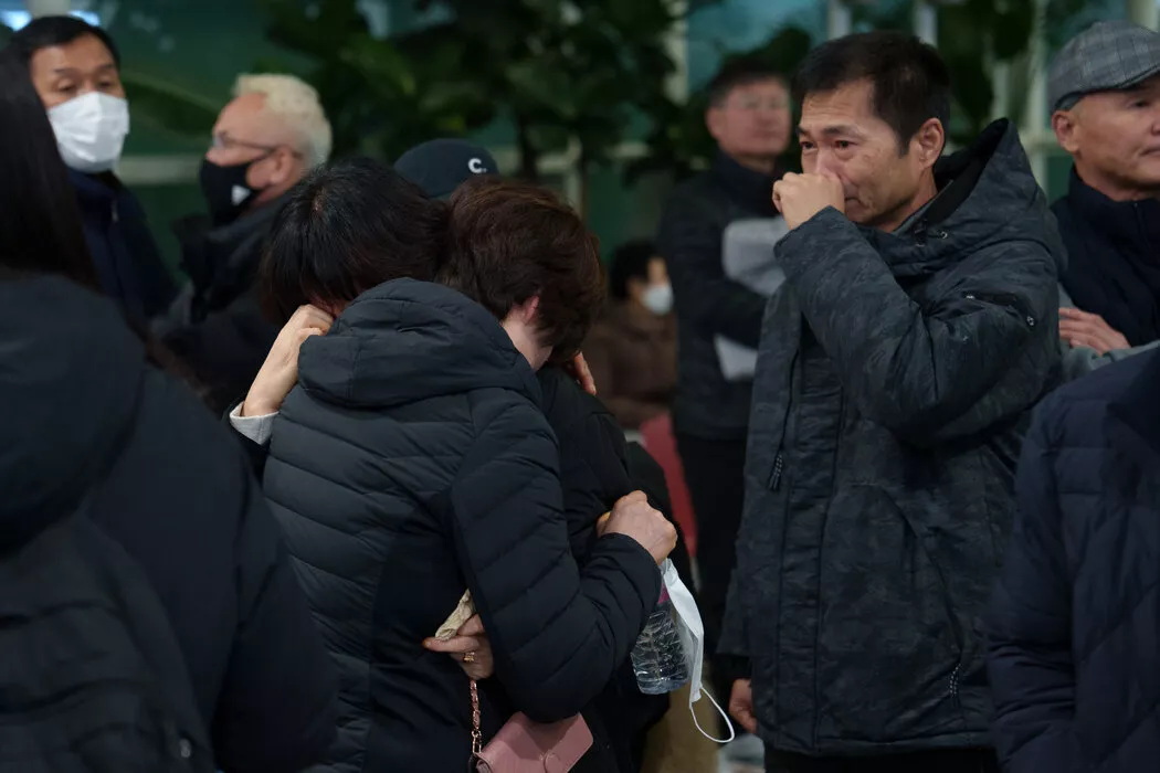 人们在务安国际机场等待关于空难遇难者的消息