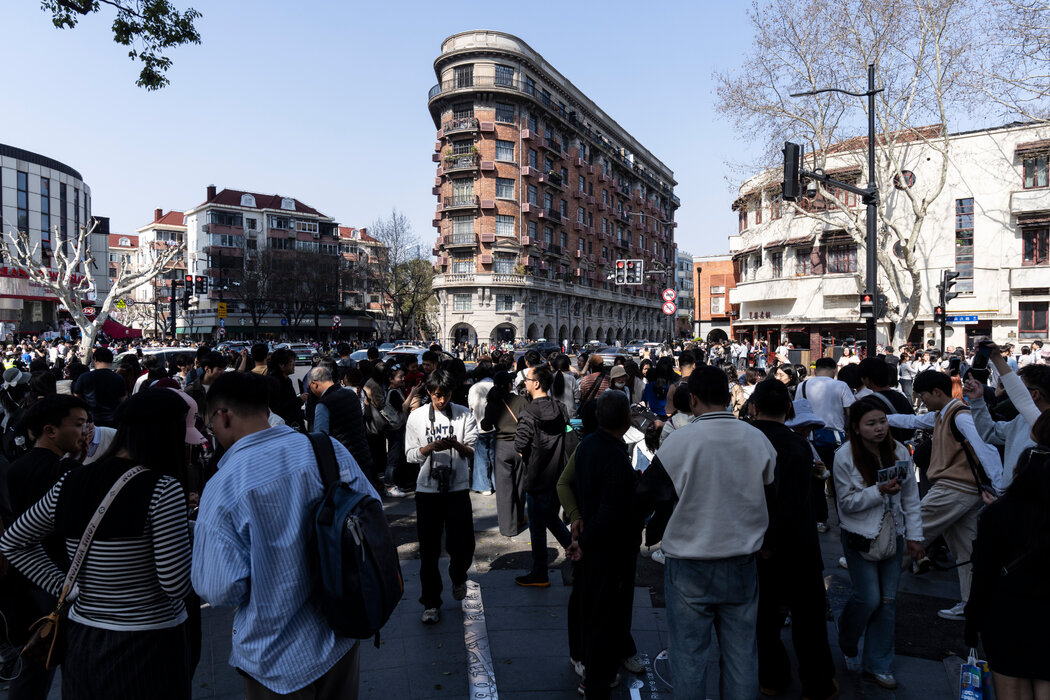 在上海的市中心，正在给一座历史建筑拍照的游客