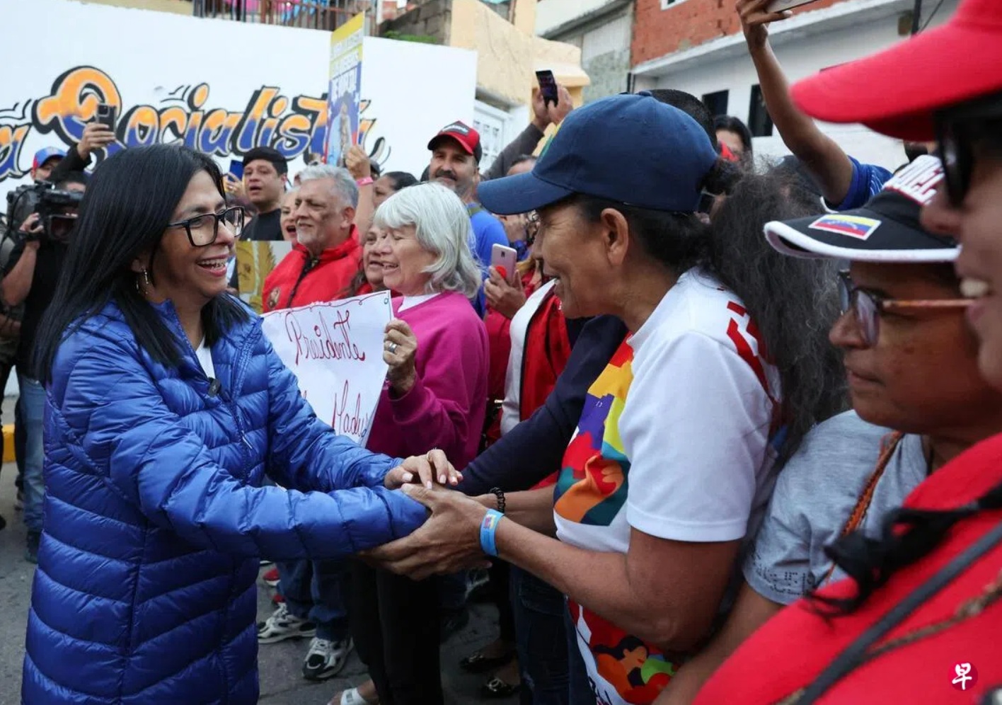 临时总统罗德里格斯（左）周二（1月6日）访问加拉加斯一处社会主义公社时与支持者互动 ...